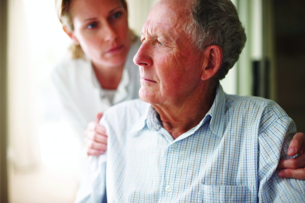 Senior problems - Nurse comforting a tensed old man while at the hospital